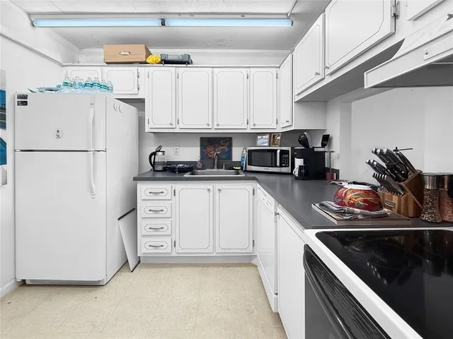 a kitchen with white cabinets and white appliances