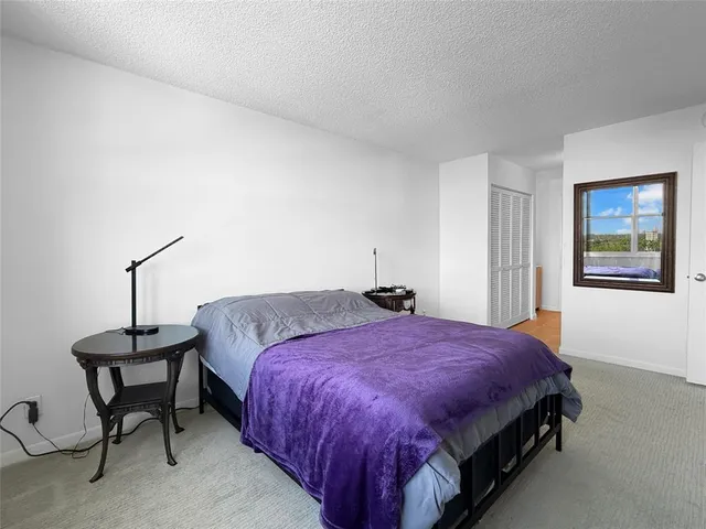 a spacious bedroom with a bed and a lamp