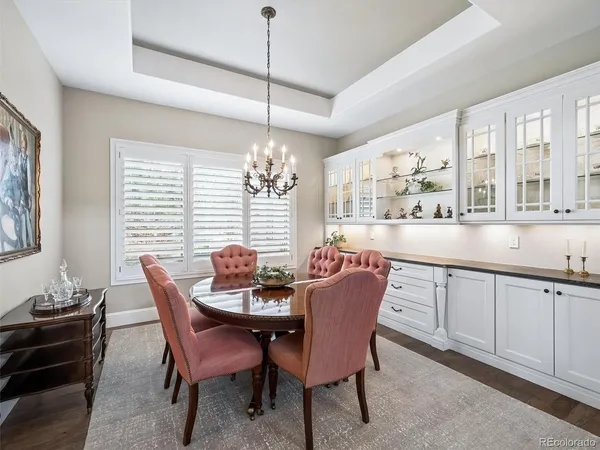 a dining room with furniture a chandelier and wooden floor