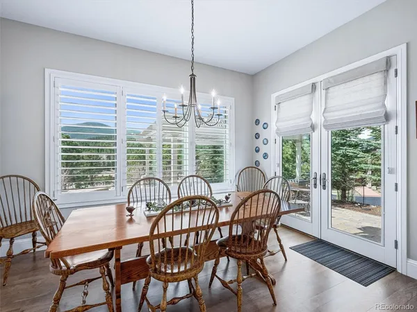 a dining room with furniture a chandelier and wooden floor