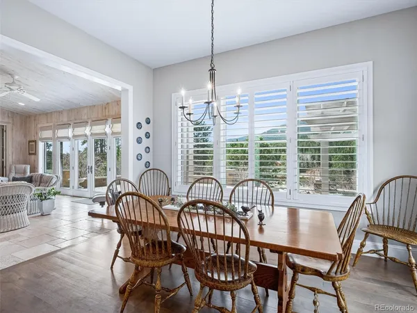 a dining room with furniture a chandelier and wooden floor