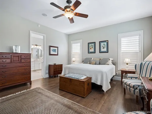 a spacious bedroom with a bed a dresser and a chandelier