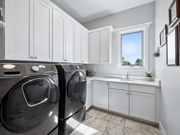 a utility room with sink dryer and washer