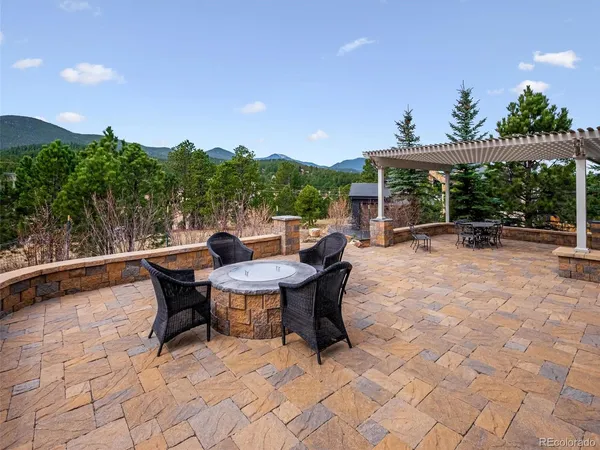 a view of backyard with table and chairs under an umbrella