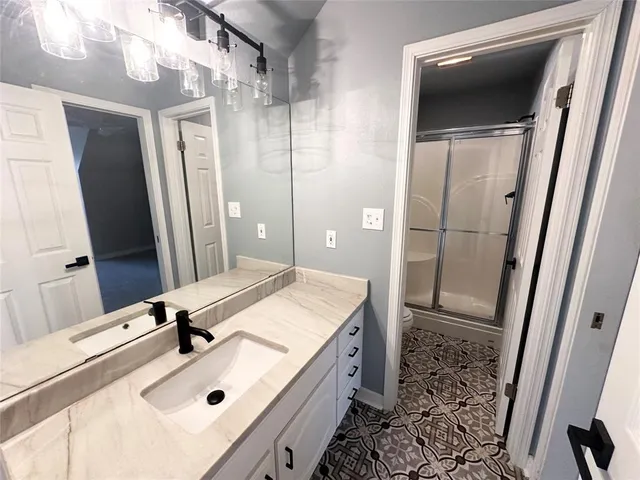 a bathroom with a sink a mirror and a shower