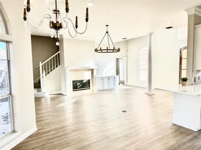 a view of a room with wooden floor fireplace and windows