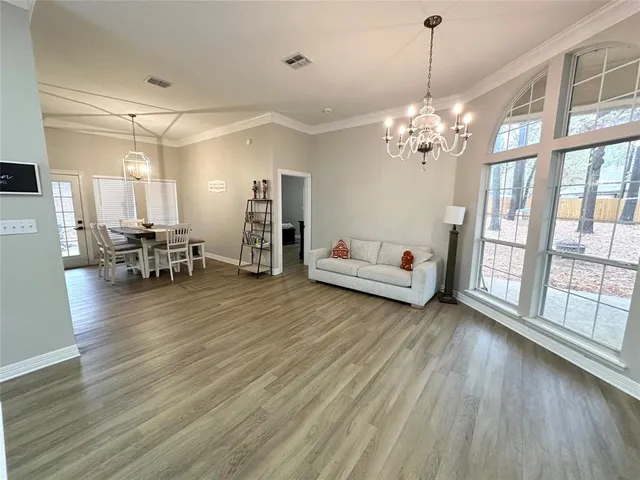 a view of a livingroom with furniture wooden floor and a chandelier