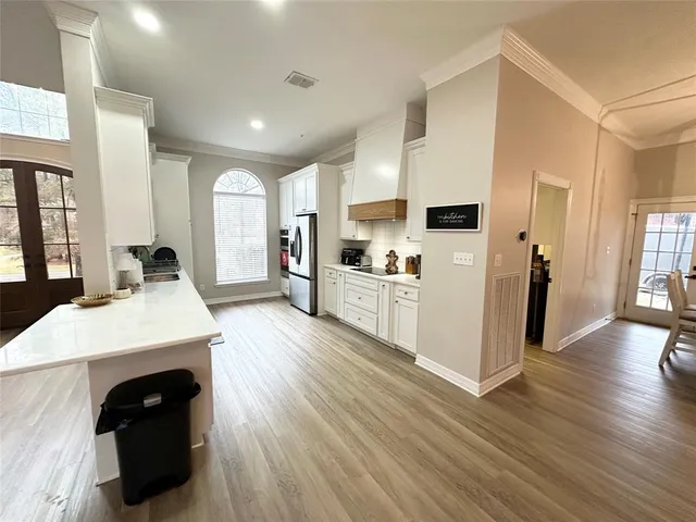 a large kitchen with cabinets and wooden floor