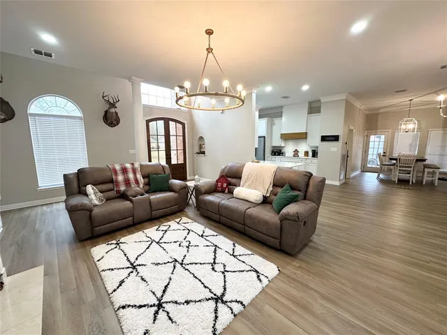 a living room with furniture and a chandelier