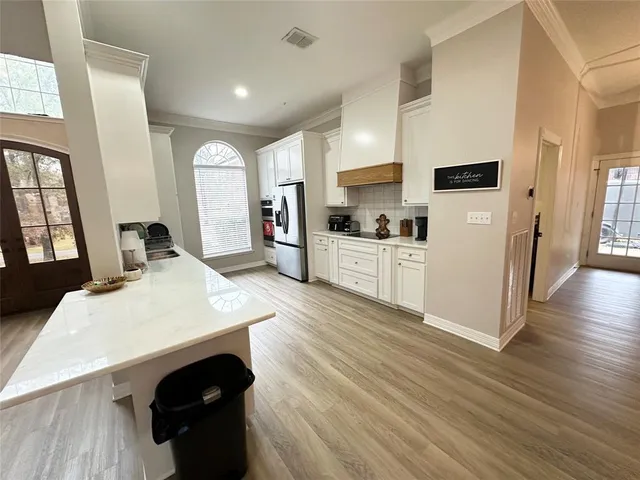 a kitchen with stainless steel appliances kitchen island sink refrigerator and stove