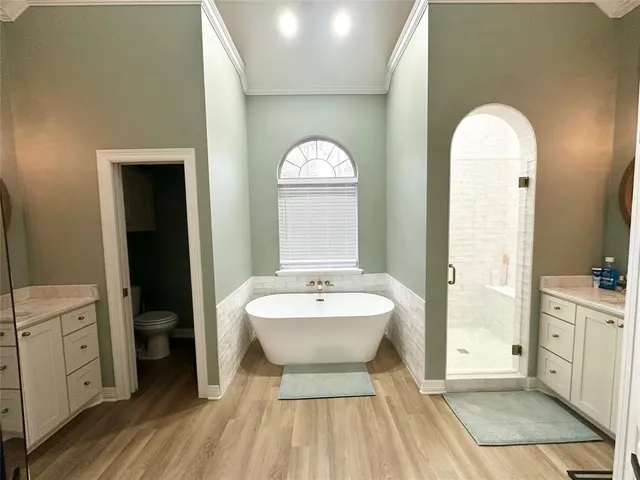 a spacious bathroom with a double vanity sink a mirror and a toilet