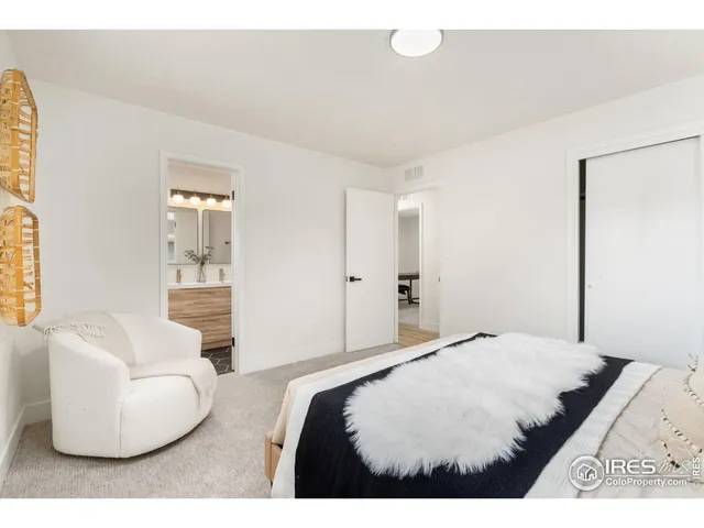 a bedroom with a white bed and white couch