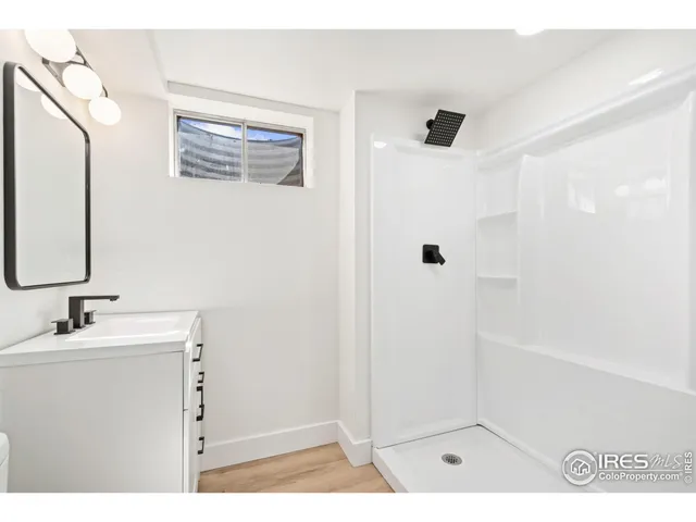 a bathroom with a sink a mirror a shower and vanity