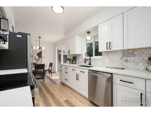 a kitchen with stainless steel appliances a sink a stove a refrigerator and cabinets