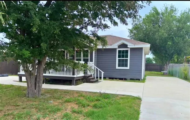 a front view of a house with a yard and trees