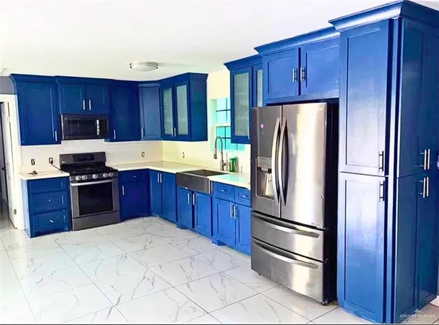 a kitchen with stainless steel appliances granite countertop a refrigerator stove and wooden cabinets