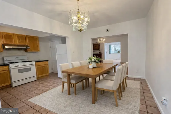 a dining room with furniture a rug and a chandelier