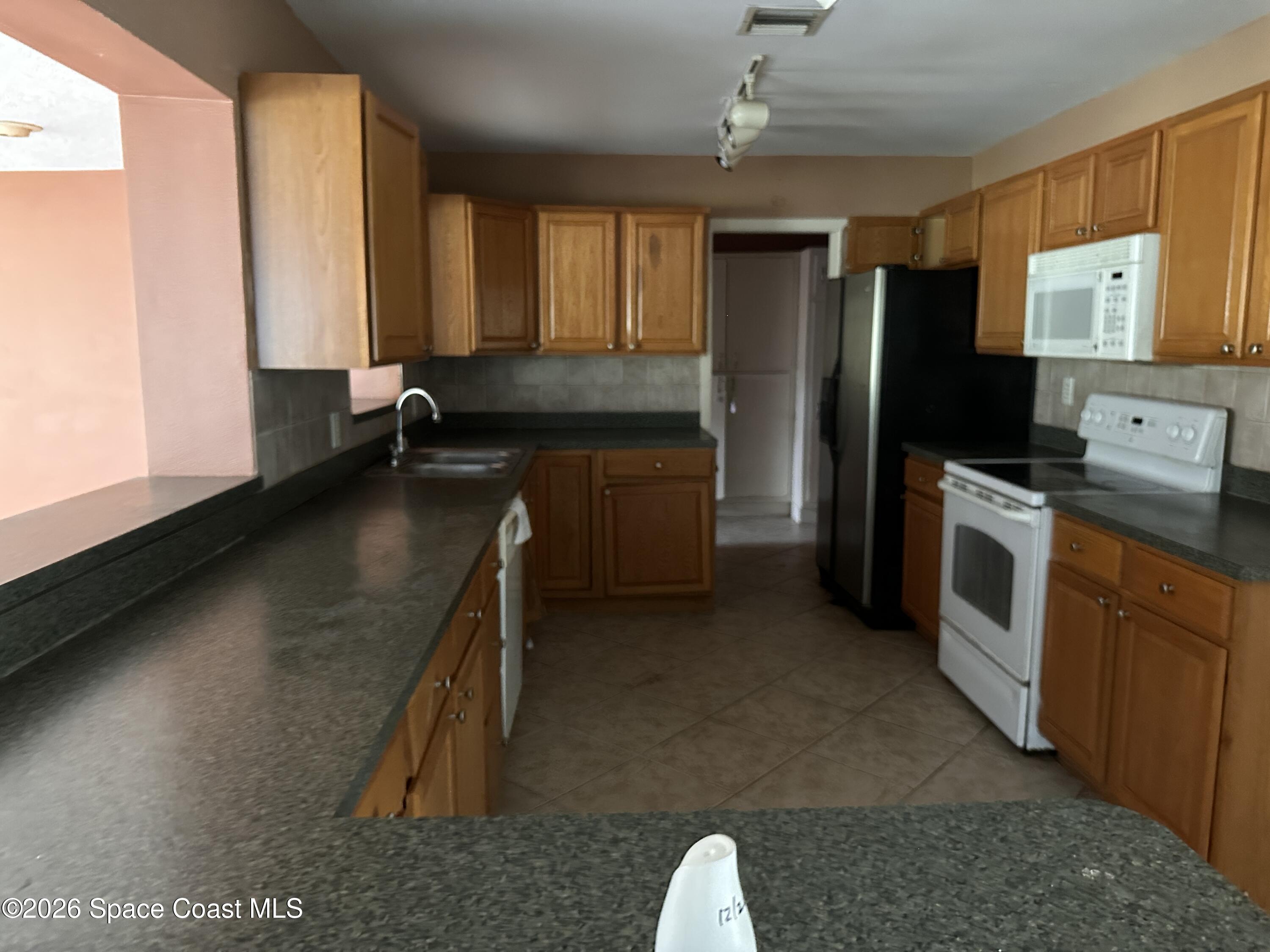 2363 Apache Drive Melbourne, FL 32935 - Photo 14 of 18 a kitchen with a sink stove and refrigerator