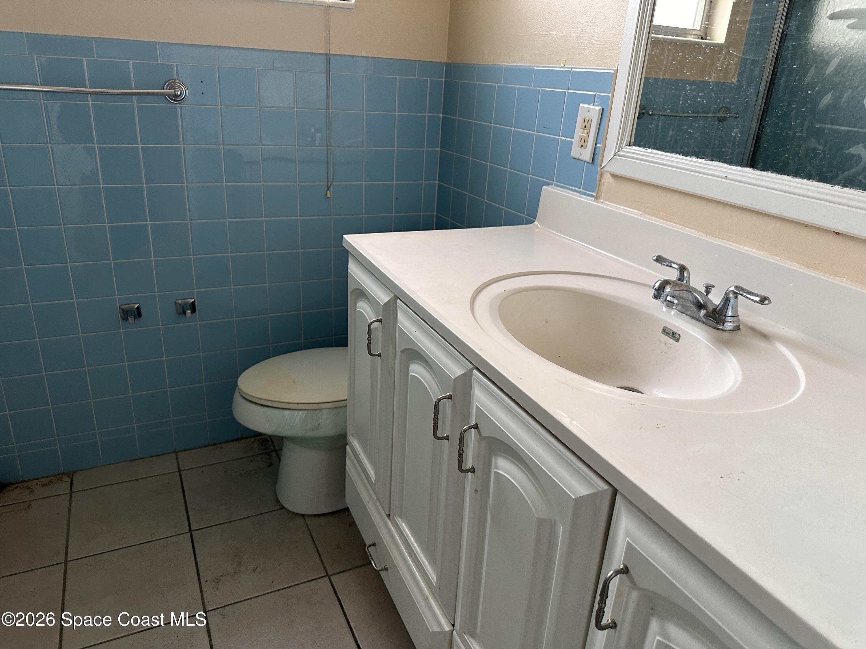 2363 Apache Drive Melbourne, FL 32935 - Photo 17 of 18 a bathroom with a sink a toilet and a mirror