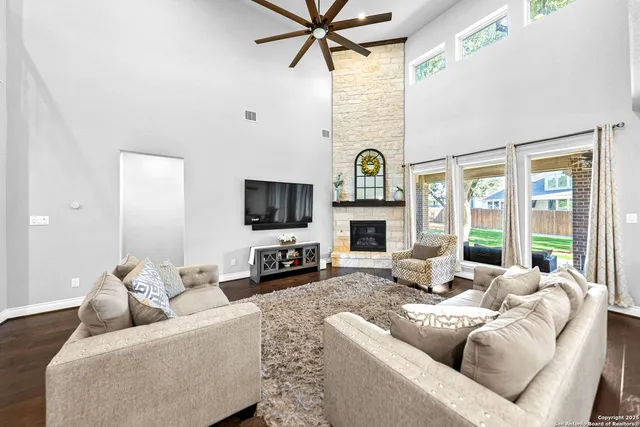 a living room with furniture a fireplace and a flat screen tv