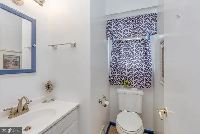 a bathroom with a toilet sink vanity and mirror
