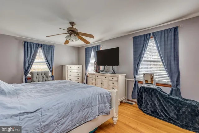 a bedroom with a bed and a flat tv screen on dresser