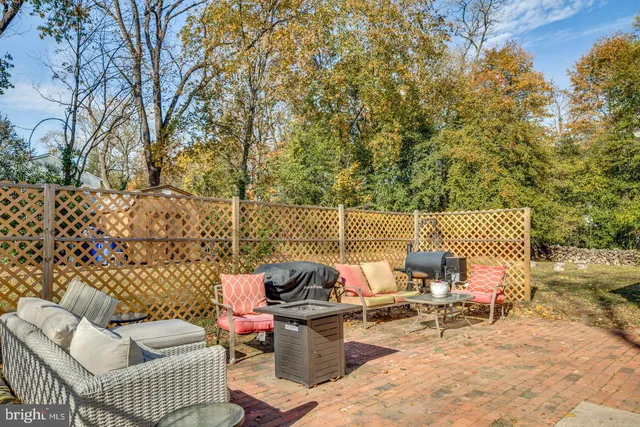 a roof deck with couches and wooden fence
