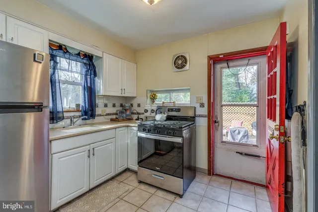 a kitchen with a stove a refrigerator and a stove top oven