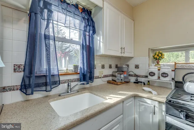 a kitchen with sink a stove and cabinets