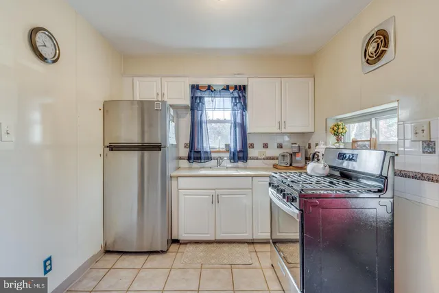 a kitchen with kitchen island granite countertop a refrigerator stove top oven and sink
