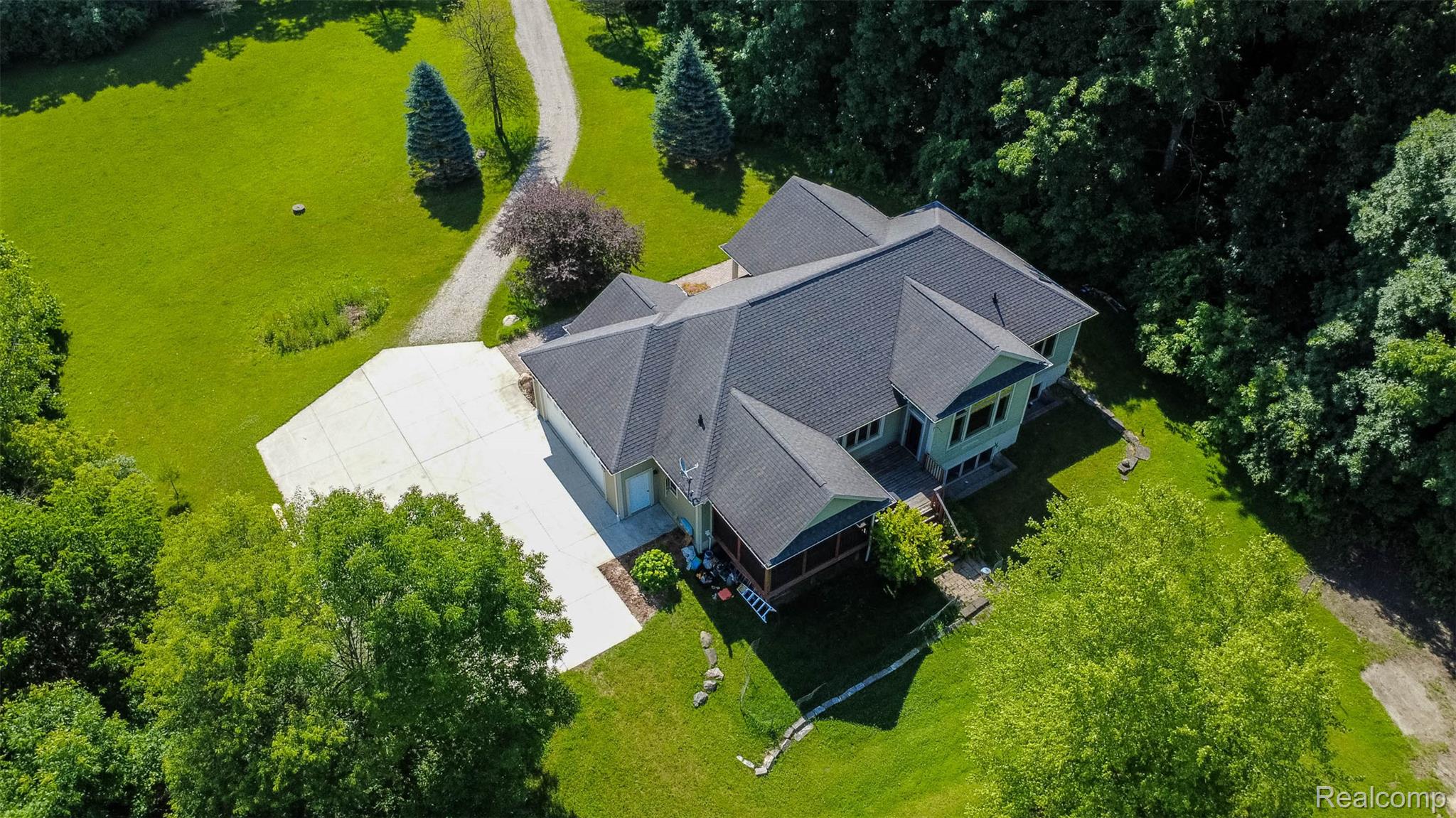 9887 Hadley Road Clarkston, MI 48348 - Photo 53 of 56 Sprawling property featuring a multi-gabled roofline, concrete driveway, and a screened porch