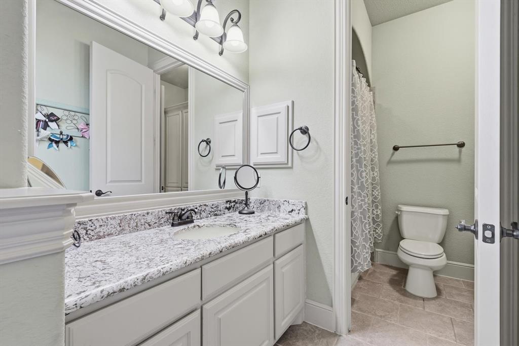 406 Spurgin Road Lucas, TX 75002 - Photo 20 of 39 a bathroom with a granite countertop sink a toilet and a mirror