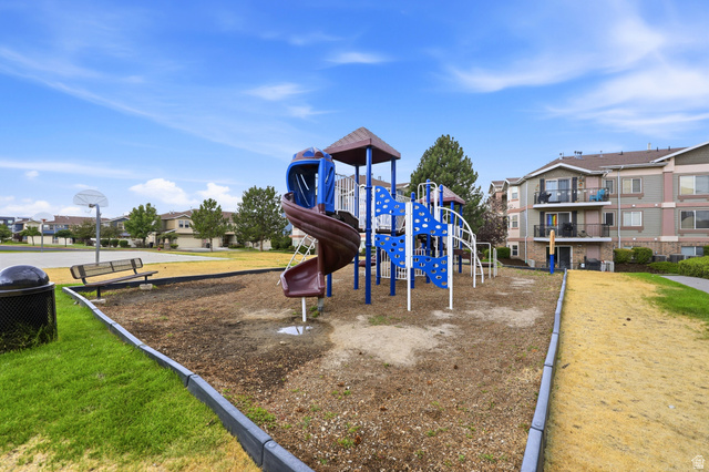 116 East Resaca Drive, Unit F6 Sandy, UT 84070 - Photo 28 of 32 Community playground featuring a multi-level play structure with slides and climbing elements, surrounded by a wood chip surface