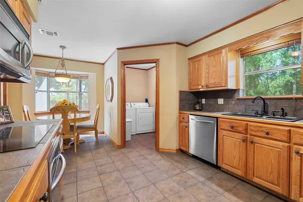 a kitchen with granite countertop a stove a sink and a refrigerator