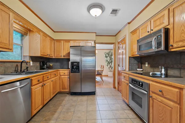 a large kitchen with stainless steel appliances granite countertop a stove and a refrigerator