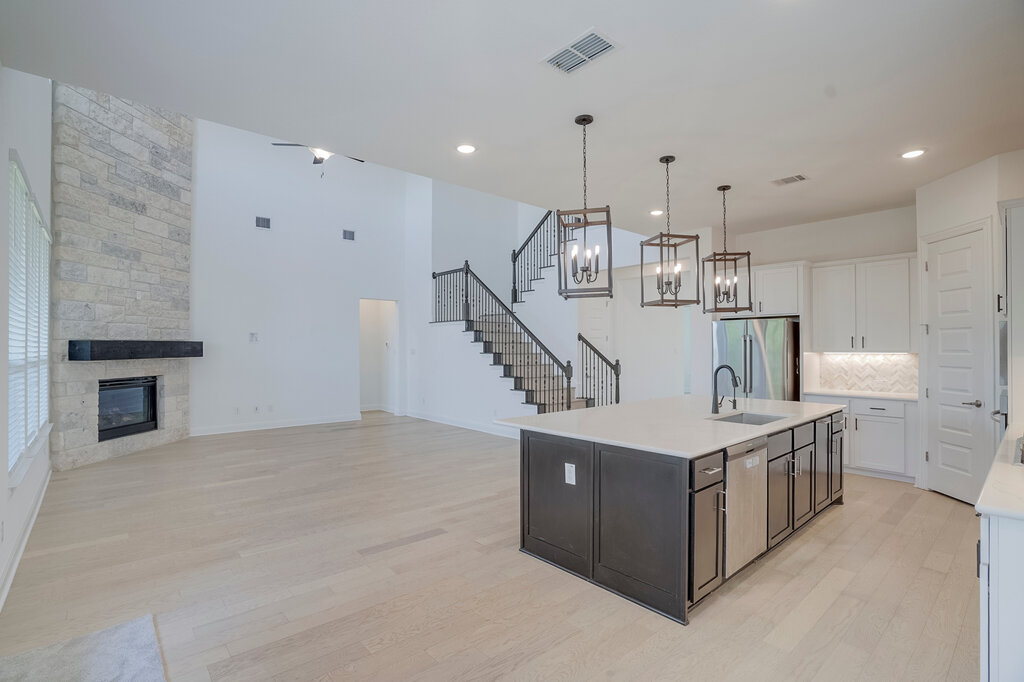2920 Hadley Way Leander, TX 78641 - Photo 6 of 20 Grand open-concept living space with a gourmet island kitchen and an impressive stone-faced fireplace.