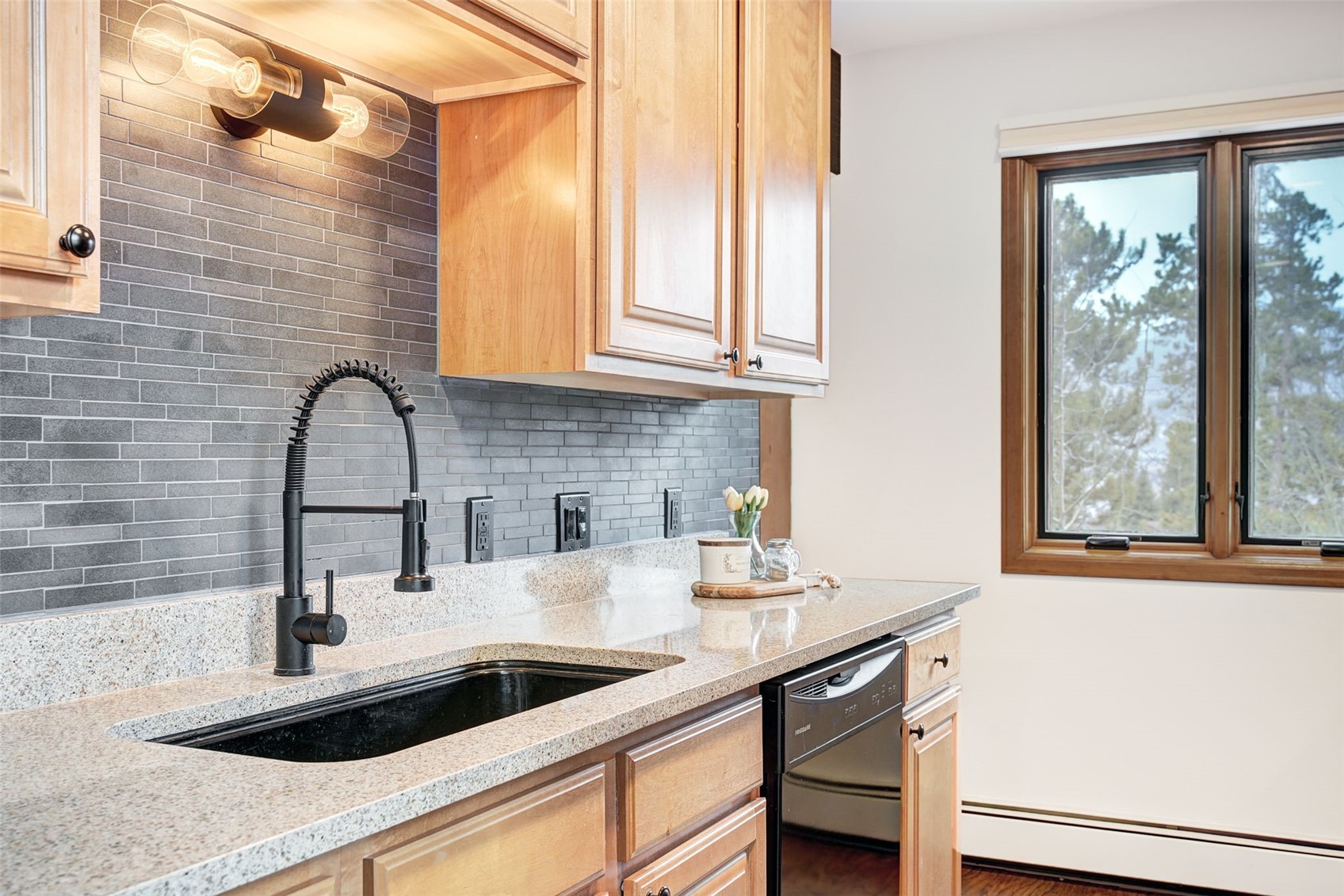 3710 Ryan Gulch Road, Unit 378 Silverthorne, CO 80498 - Photo 11 of 31 Kitchen featuring light stone counters, light wood finish cabinets, and backsplash