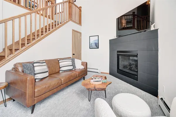 a living room with furniture a fireplace and a flat screen tv