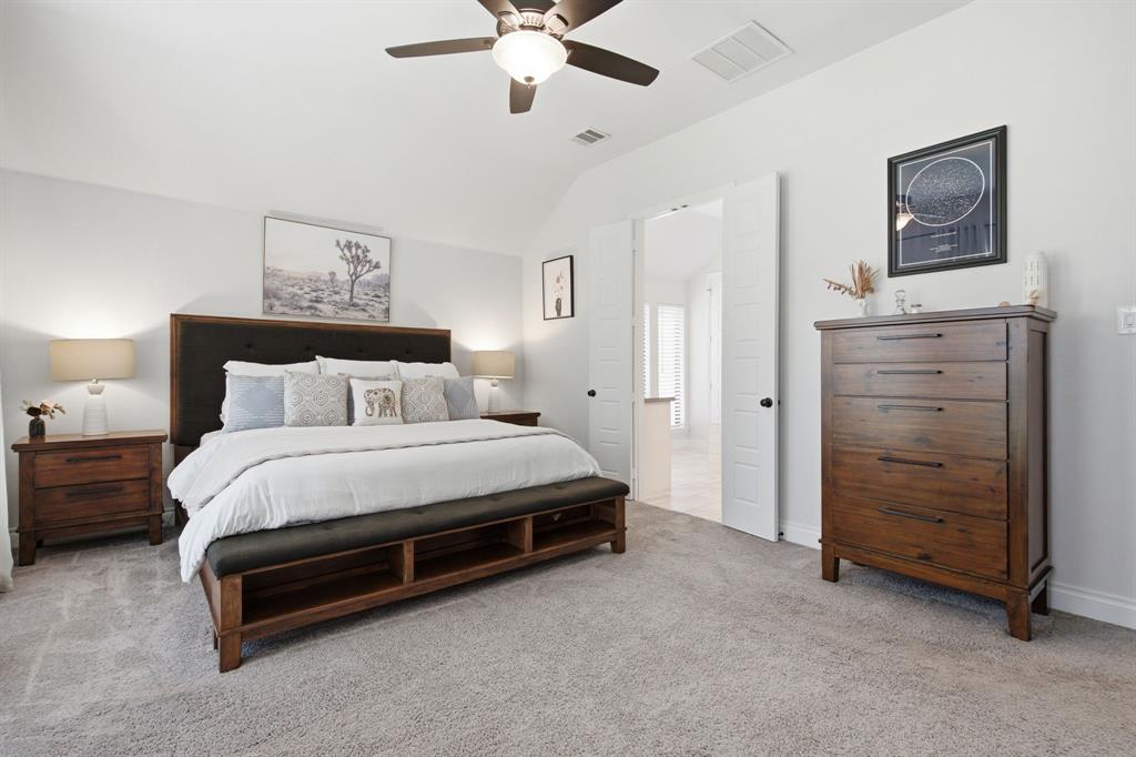904 Fallbrook Avenue Denton, TX 76210 - Photo 19 of 30 a spacious bedroom with a bed and a chandelier