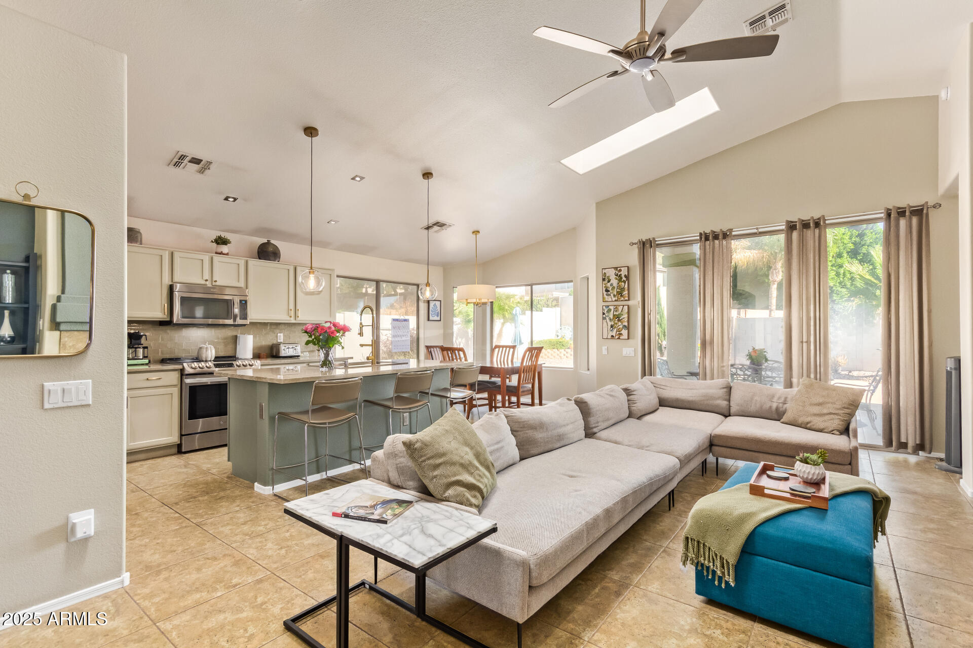 a living room with furniture kitchen view and a large window
