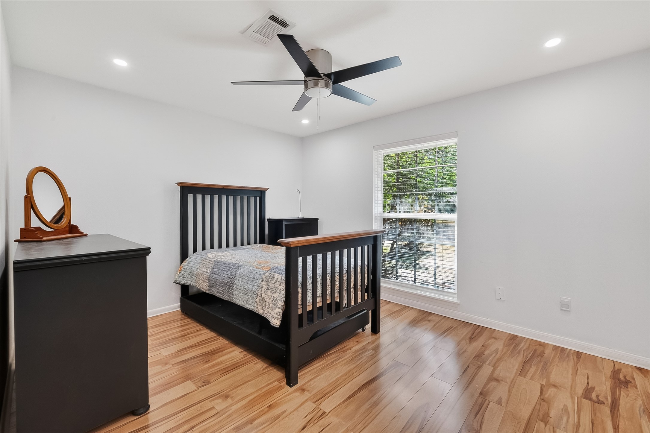 7014 Concho Street Houston, TX 77074 - Photo 32 of 46 Another secondary bedroom; this faces the front of the house. It features laminate wood flooring, large window, recessed lighting and a ceiling fan.