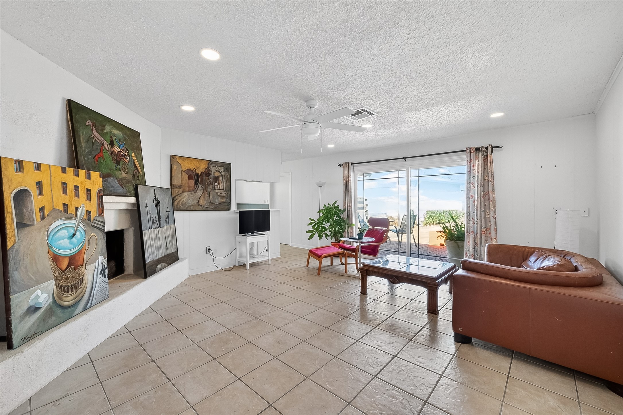 7014 Concho Street Houston, TX 77074 - Photo 8 of 46 The family room is spacious and has sliding glass doors leading to the backyard, wood burning fireplace, fan, recessed lighting and tile.