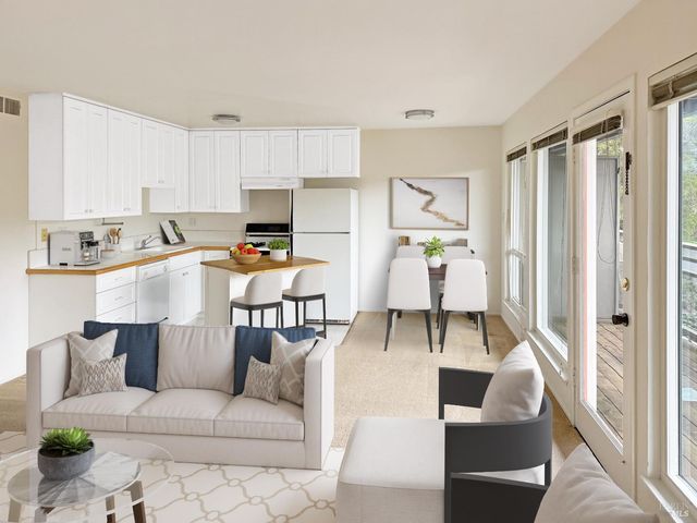 a living room with furniture and a dining table with kitchen view