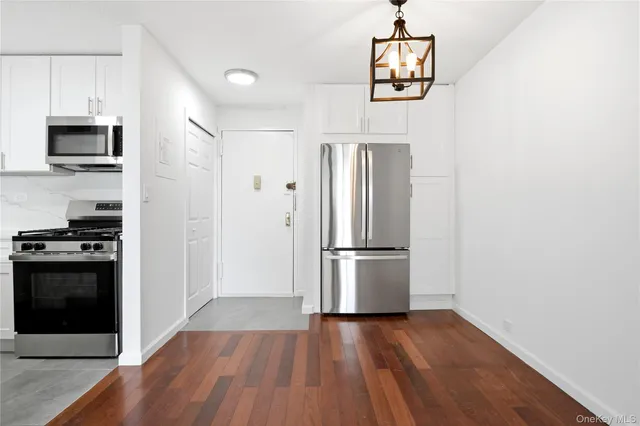 a kitchen with stainless steel appliances granite countertop a refrigerator and a stove top oven