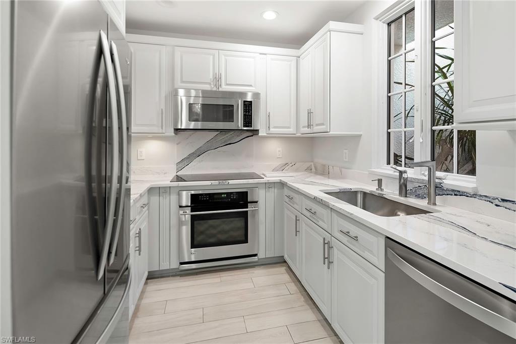 1160 Clam Court, Unit 3 Naples, FL 34102 - Photo 11 of 50 a kitchen with stainless steel appliances granite countertop a sink and a stove