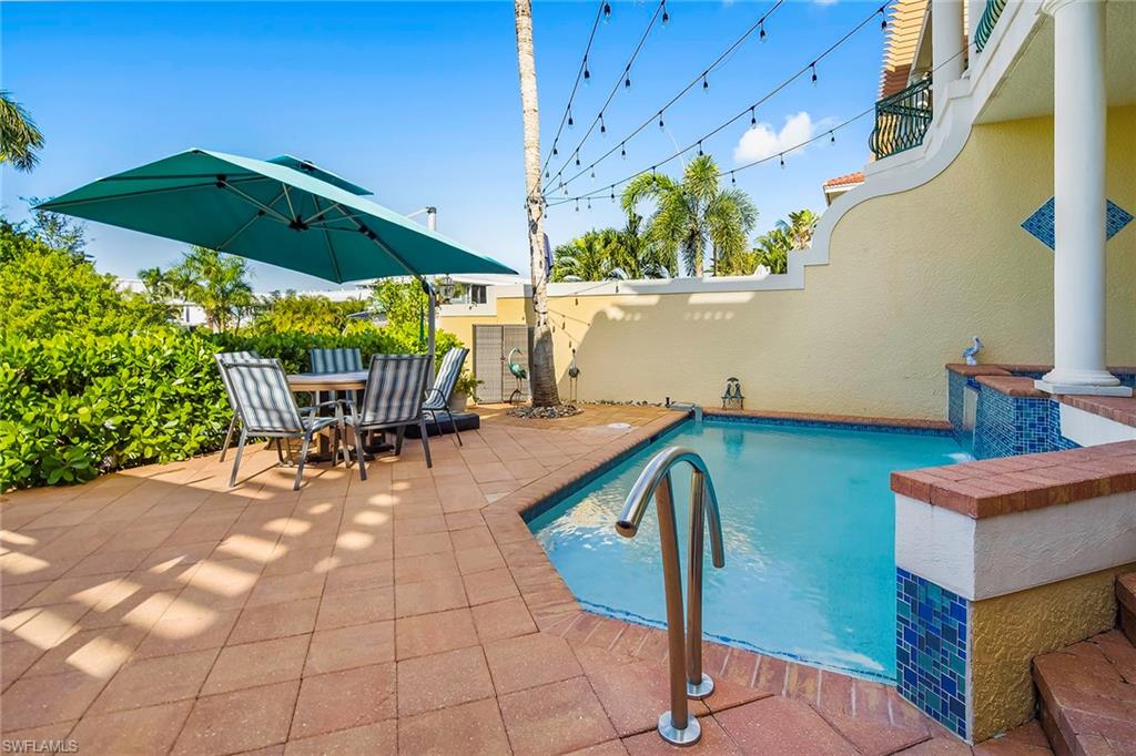 1160 Clam Court, Unit 3 Naples, FL 34102 - Photo 39 of 50 a view of patio with table and chairs under an umbrella