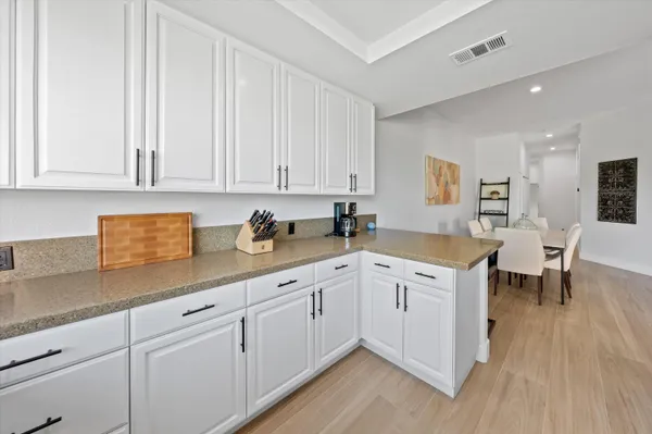 a kitchen with granite countertop white cabinets and white appliances