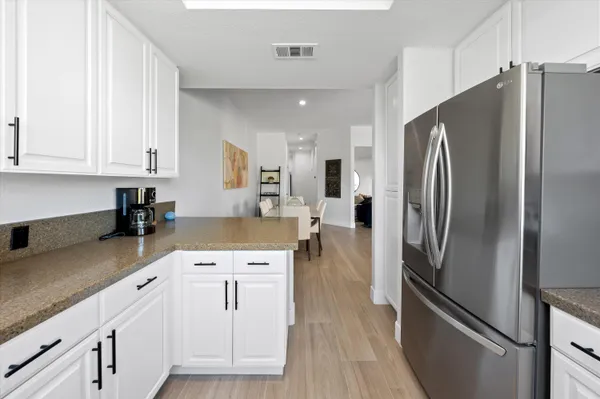 a kitchen with white cabinets and stainless steel appliances
