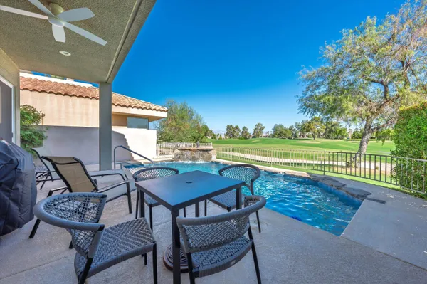 a view of a chairs and table in patio with a yard