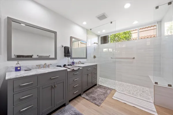 a bathroom with a double vanity sink mirror and shower